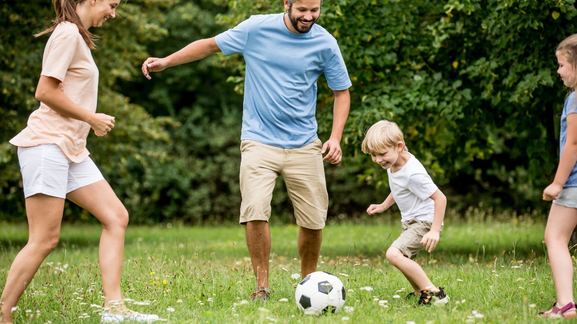 Barn och föräldrar spelar fotboll